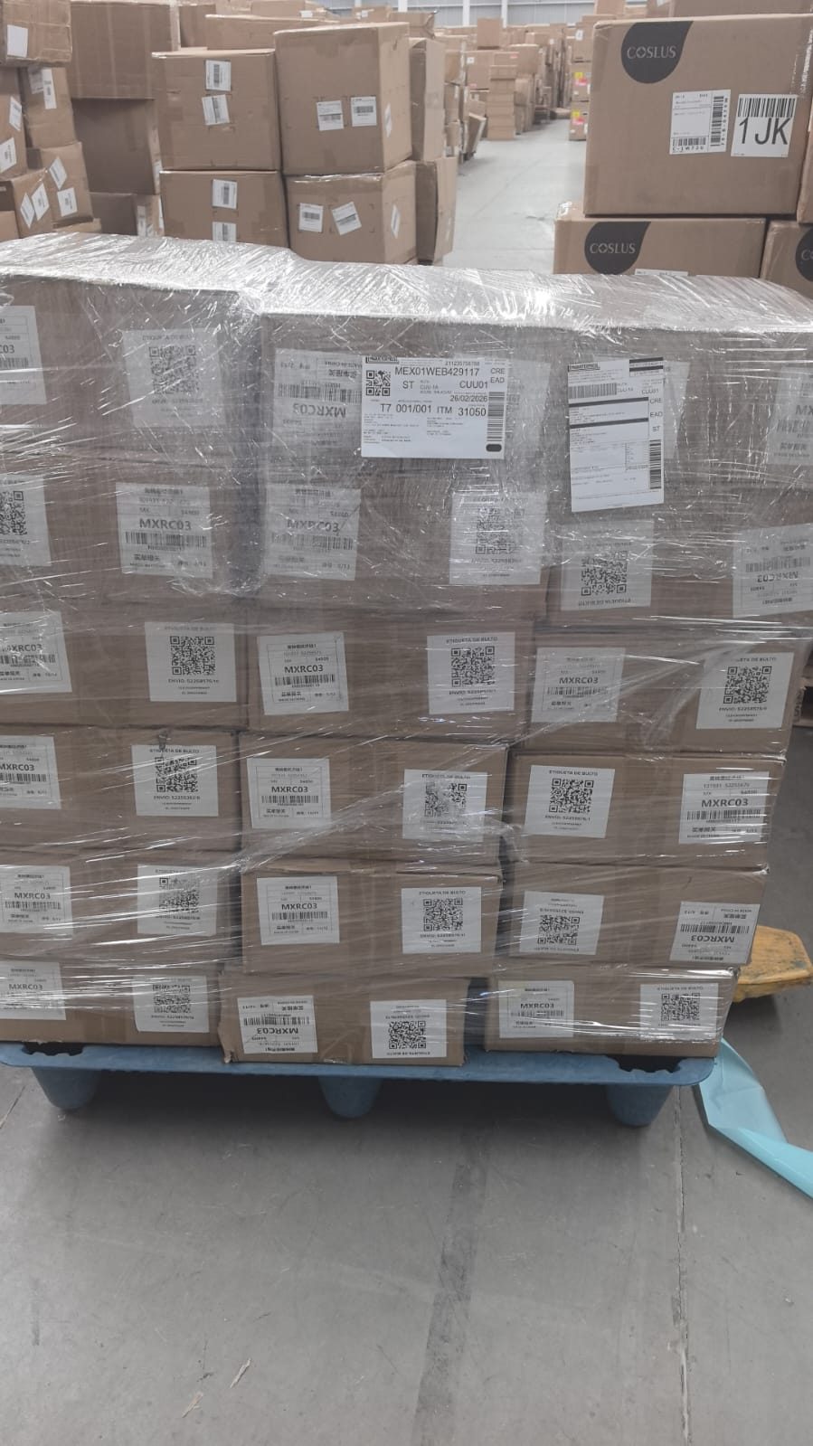 Pallet de mercancía con bodega al fondo, mostrando volumen operativo